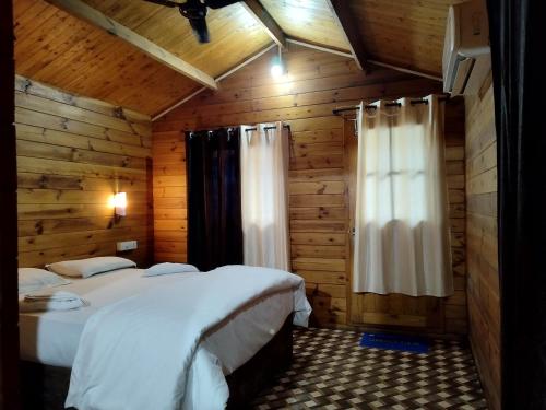 帕特南Roundcube Beach Bungalows Patnem的小木屋内一间卧室,配有两张床