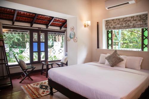 MoiraLamrin Ucassaim Goa A 18th Century Portuguese Villa的卧室设有白色大床和窗户。