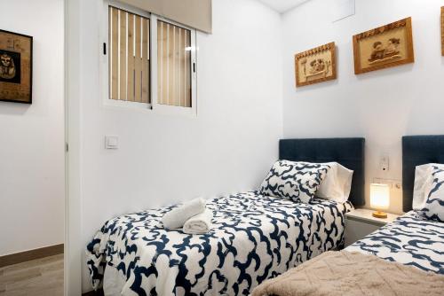 巴尔巴特Apartamento El Músico的白色墙壁客房的两张床
