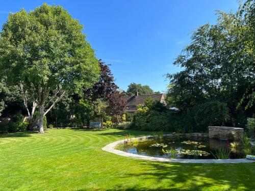 吉尔福德阿斯佩里昂山坡酒店的庭院中间带池塘的花园