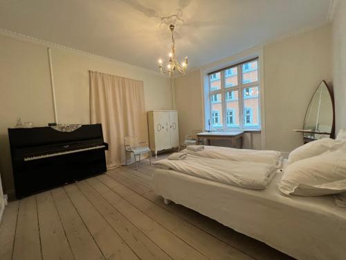 哥本哈根Outhentic Apartment的一间卧室配有一张床和一架钢琴