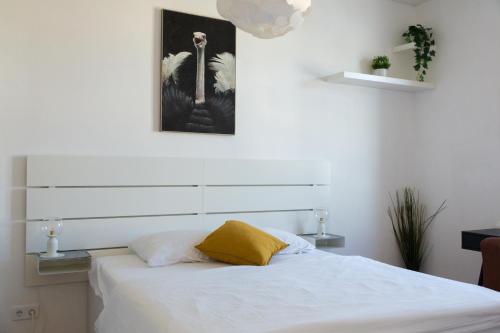格拉茨Pleasant City Apartment的卧室配有白色床和黄色枕头