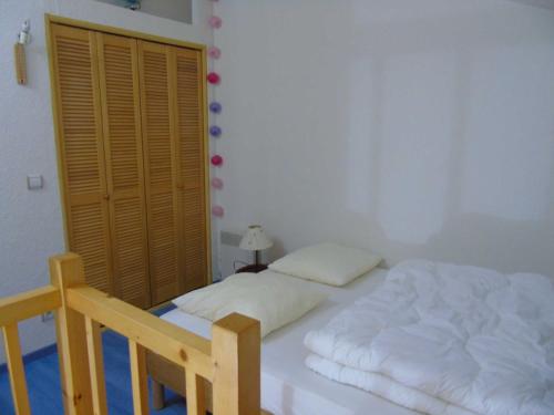瓦尔弗雷加斯Appartement Valfréjus, 2 pièces, 4 personnes - FR-1-561-50的卧室配有白色的床和木制橱柜。