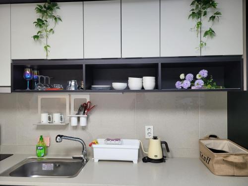 大邱DAON STAR BnB j6的厨房柜台配有水槽和白色橱柜