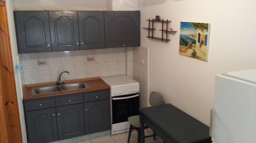 斯卡拉马里昂Veroniki Apartment的一间小厨房,配有黑色橱柜和水槽