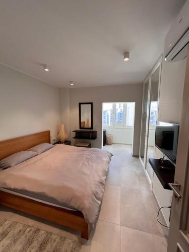 帕切维拉Luxury Private Room - TV的一间卧室配有一张床和一台平面电视