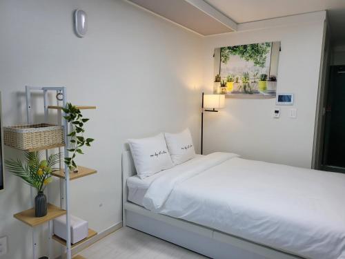 大邱DAON STAR BnB j6的一间卧室配有带白色床单和枕头的床。