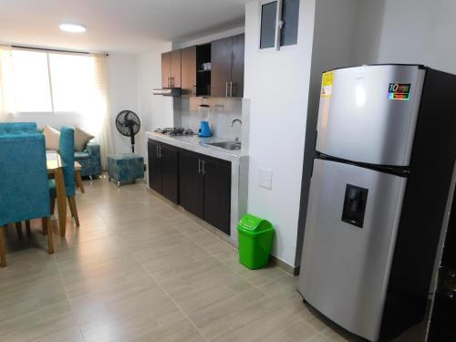 圣玛尔塔El Velero Apartamentos By DANP的厨房配有冰箱和桌椅