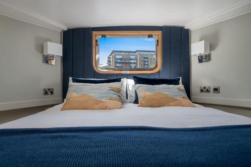 伦敦Luxurious houseboat near Canary Wharf in London的一间卧室设有一张大床和窗户