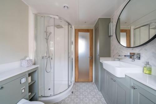 伦敦Luxurious houseboat near Canary Wharf in London的带淋浴、盥洗盆和镜子的浴室