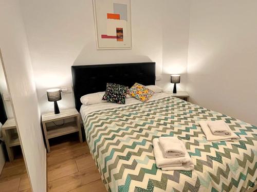 布拉内斯Apartamento cerca de la playa的一间卧室配有带枕头的床