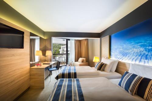 奥帕提亚Hotel Admiral - Liburnia的酒店客房设有两张床和电视。