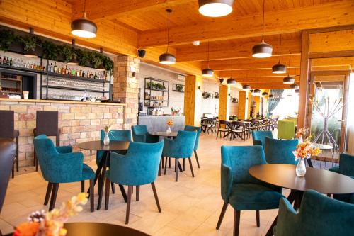 佩济诺克罗扎尔卡酒店的一间设有蓝色桌椅的餐厅和一间酒吧