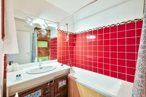 巴黎Superbe appartement grand et lumineux au 12ᵉ Paris的一间带水槽和红色瓷砖墙的浴室