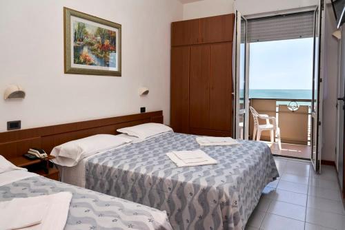 里米尼大西洋酒店的酒店客房设有两张床和一个阳台。