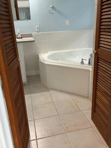 Royal Palm Villas的带浴缸的浴室和瓷砖地板。