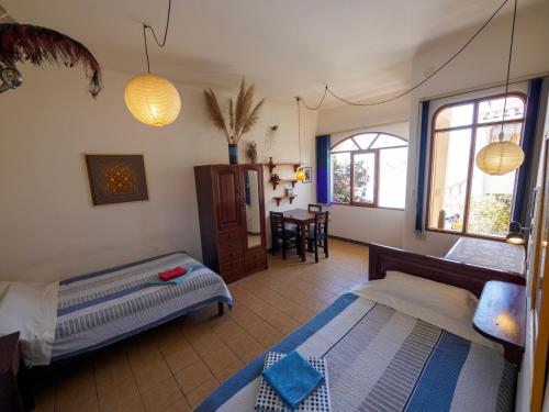 苏克雷Bella Vista El Tronco的一间卧室设有两张床、一张桌子和窗户。