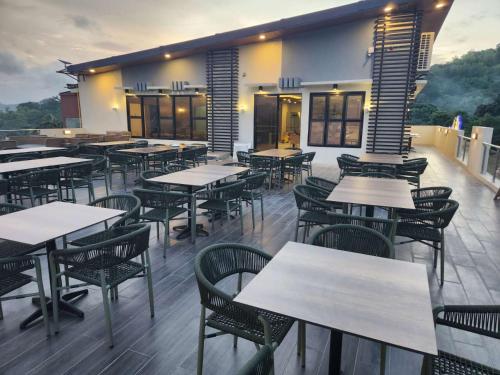 科隆Tropicasa Coron Resort & Hotel的一间在甲板上配有桌椅的餐厅