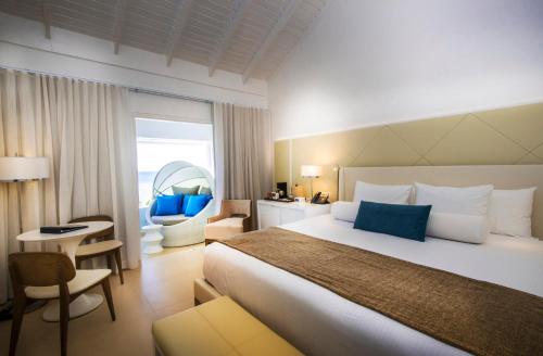尼格瑞尔Azul Beach Resort Negril, Gourmet All Inclusive by Karisma的酒店客房带一张大床和一把椅子
