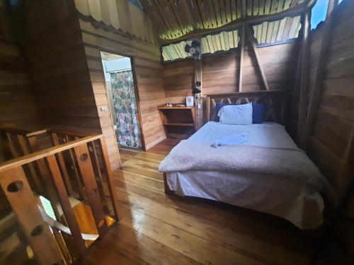 UpalaOski Lodge, Rain Forest Rincón de la Vieja的小木屋内一间卧室,配有一张床