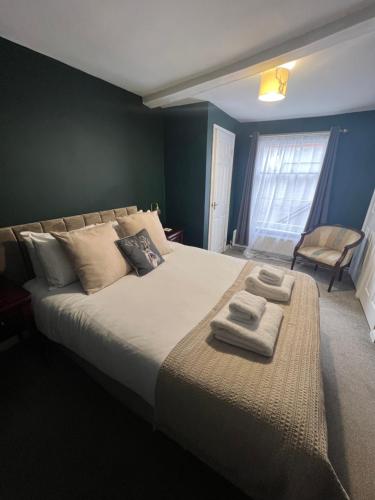 RickinghallThe Bell Inn, Rickinghall的一间卧室配有一张大床和两条毛巾