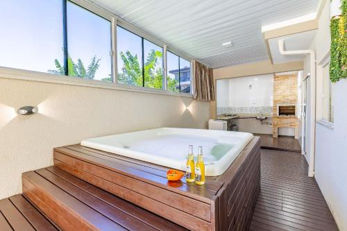 邦比尼亚斯Casa com Jacuzzi ideal para Férias de Famílias - 3 dorms 6 pessoas的带窗户的浴室设有大浴缸