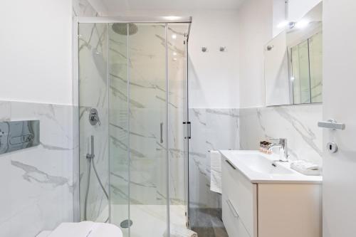 都灵Exclusive Loft Crocetta - Free Private Parking & Wi-Fi - 5 min To Metro Nizza的带淋浴和盥洗盆的白色浴室