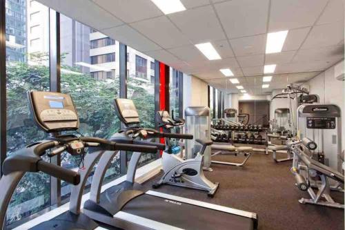 布里斯班Brisbane Midtown - Centre of CBD w Pool, Gym, Sauna的大楼内带跑步机和椭圆机的健身房