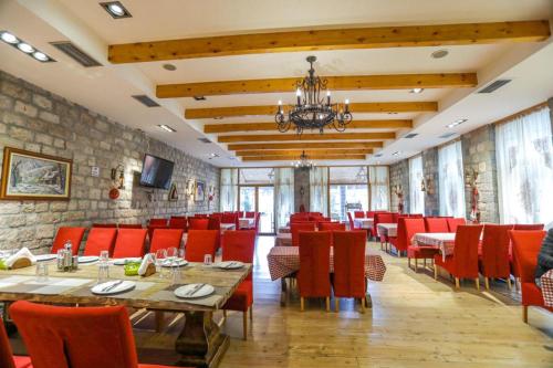 沃斯科波亚Vila Falo的一间设有红色桌椅和石墙的餐厅