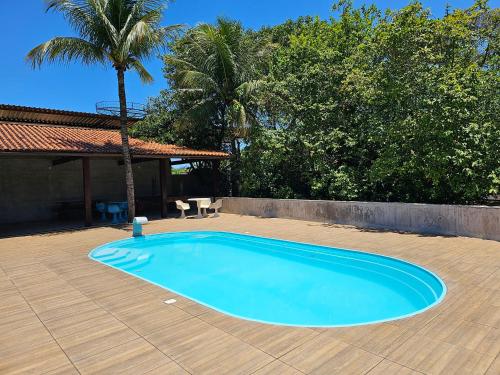 里约博尼图HOTEL INDIANO的木制庭院中的一个大型蓝色游泳池