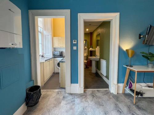 格拉斯哥Cozy Studio Apartment of Glasgows West End的厨房设有蓝色的墙壁和走廊