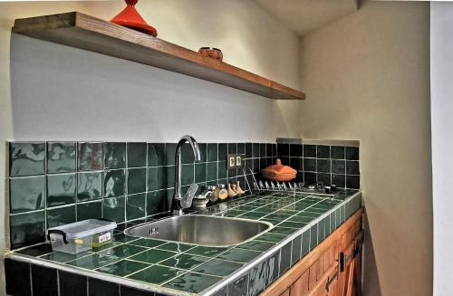 舍夫沙万Aparthotel Dar Nowara Chaouen的厨房配有水槽和绿色台面