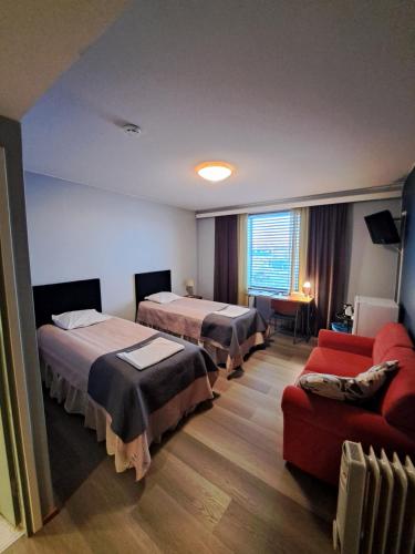 凯尔赛迈基Hotelli Kärsämäki的酒店客房,设有两张床和一张沙发