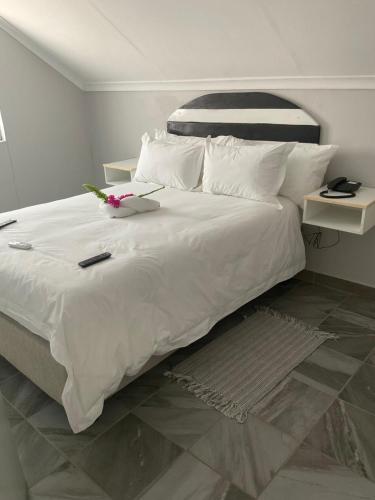 卡蒂马穆利洛Riverside Lodge的一间卧室配有一张白色大床,床上有鲜花