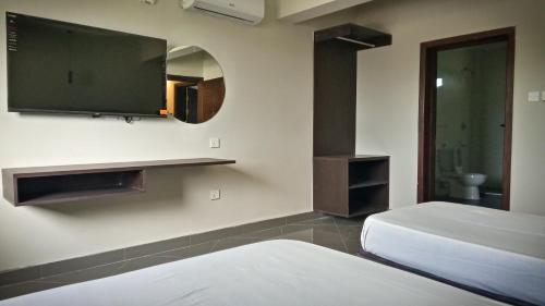 纳库鲁Ivory Park Hotel - Safari Waterworld的一间卧室配有两张床和一台平面电视