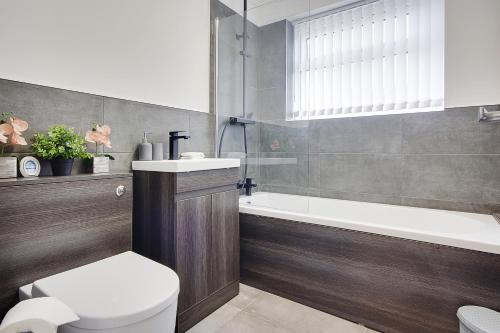 浦耳17 Banstead Road的浴室配有卫生间、浴缸和水槽。