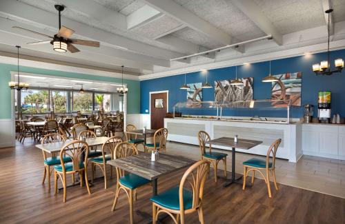 默特尔比奇代顿豪斯度假酒店的餐厅设有桌椅和蓝色的墙壁