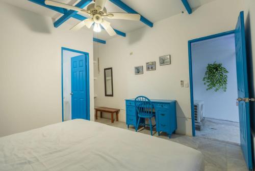 南圣胡安Hostel SaltWater的一间卧室配有蓝色梳妆台和吊扇