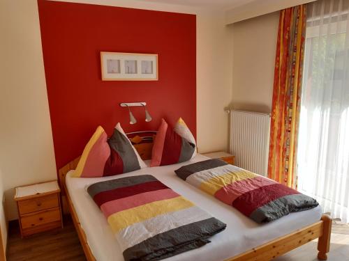 玛丽亚阿尔姆豪斯桑美尔斯坦公寓的一间卧室配有一张红色墙壁的床