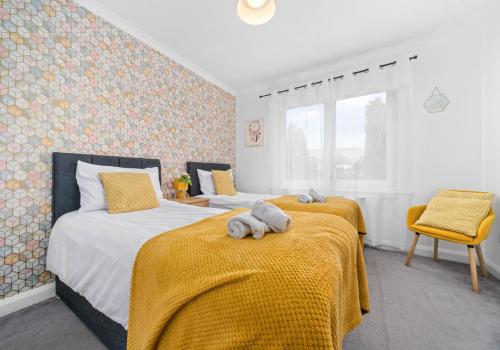 马瑟韦尔Anderson Apartment by Klass Living Motherwell的一间卧室配有两张带黄色毯子的床