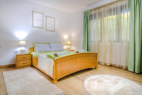 威尔帕扎Pavle's Oasis的一间卧室设有床铺和一个带绿色窗帘的窗户。