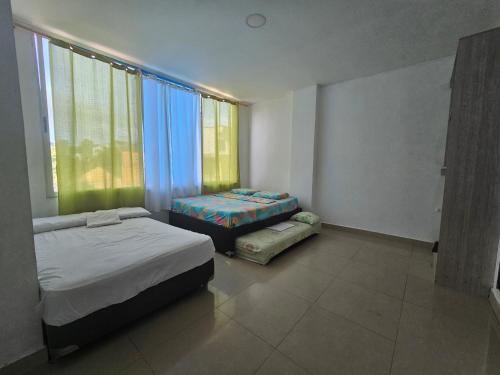 内科克利Brisa Marina Apartaestudios的一间卧室设有两张床和大窗户