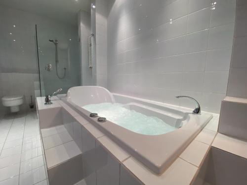 门兴格拉德巴赫Exklusives Penthouse 232QM Whirlpool 28min bis Düsseldorf Messe的白色的浴室设有浴缸和卫生间。