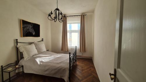 HoymHistorisches Badehaus的一间卧室配有一张带吊灯和窗户的床。