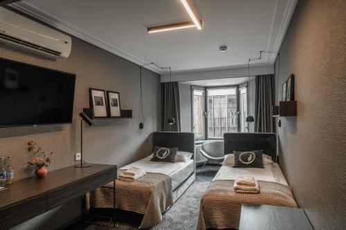 克拉科夫Hotel Logos Kraków的酒店客房设有两张床和电视。