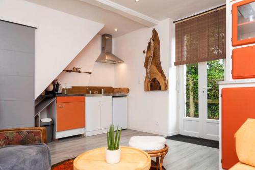 Saint-Martin-des-EntréesMaisonnette duplex avec jacuzzi/sauna attenant的一间厨房和一间橙色及白色的客厅