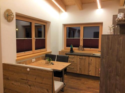 胡本Haus Bergjuwel的厨房配有木桌、椅子和窗户。