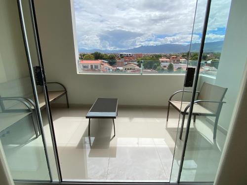 塔里哈Departamento tres dormitorios的客房设有桌子、两把椅子和窗户。