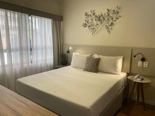 圣保罗Flat Jardins, entre Av Paulista e Parque do Ibiraquera的卧室配有一张大白色床和窗户