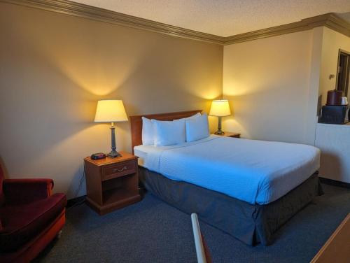 麦克默里堡诺玛德套房酒店的配有一张床和一把椅子的酒店客房